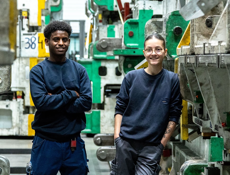 Zwei Auszubildende in einer Produktionshalle.