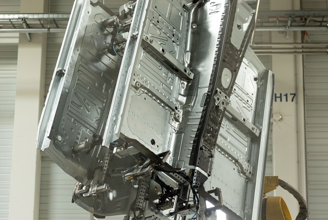 Automatisierte Anlage für Karosseriebau in moderner Fertigungshalle.