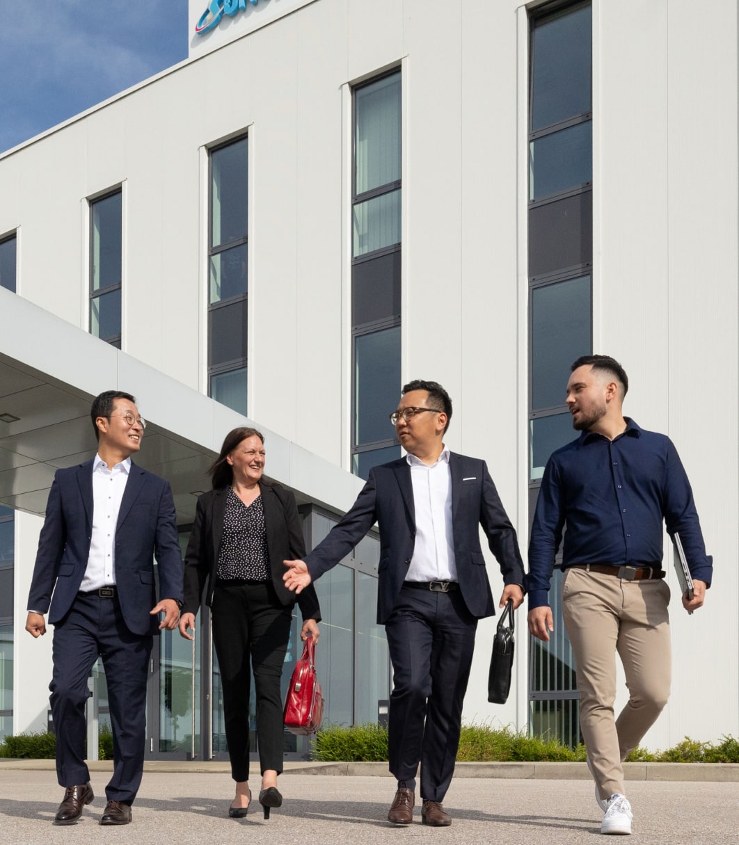 Eine Personengruppe vor dem Gebäude von Sungwoo Hitech.