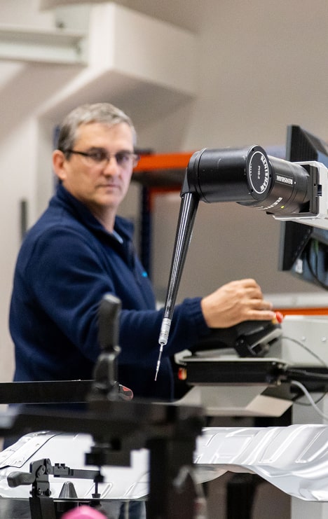 Mitarbeiter bei der Prüfung eines Bauteils.